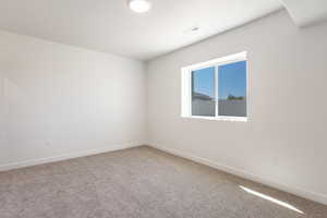 Spare room with light carpet and baseboards