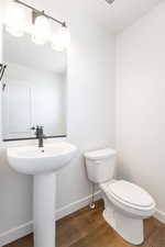 Half bathroom with baseboards and dark wood-style floors