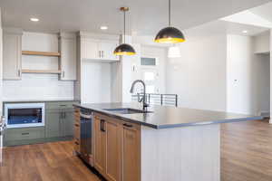 Kitchen featuring dark wood-style flooring, hanging light fixtures, recessed lighting, decorative backsplash, and open shelves