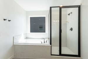 Bathroom featuring a bath and a shower stall