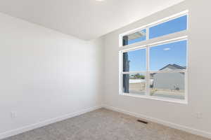 Spare room featuring baseboards and carpet flooring