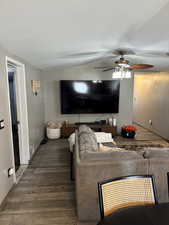 Living room featuring wood-type flooring, lofted ceiling, and ceiling fan