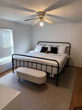 Bedroom featuring wood finished floors, a textured ceiling, and a ceiling fan