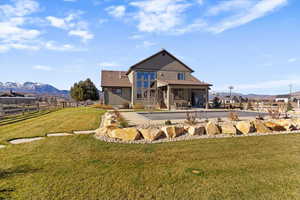 Rear view of property with a mountain view, a patio, driveway, and a garage