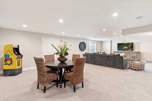 Dining area with light colored carpet and recessed lighting