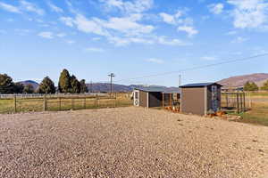 View of yard with a mountain view, a storage unit, and a rural view