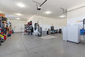 Garage featuring freestanding refrigerator and a garage door opener