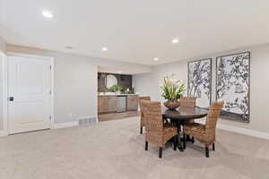 Dining room featuring recessed lighting and light colored carpet