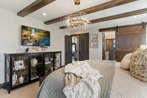 Carpeted bedroom featuring a barn door, a chandelier, recessed lighting, and beam ceiling