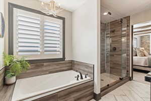 Bathroom featuring a shower stall, a bath, ensuite bath, and plenty of natural light