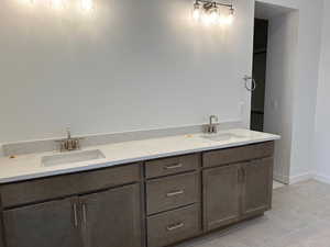 Bathroom with double vanity and light tile patterned floors