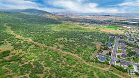 Aerial view of property and surrounding area featuring a mountain backdrop and property parcel outlined