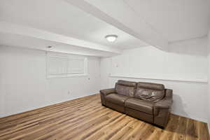 Living room with wood finished floors and beam ceiling