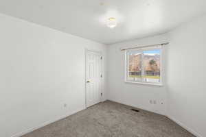 Empty room with carpet floors and baseboards