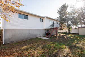 Rear view of property featuring stairway and a shed