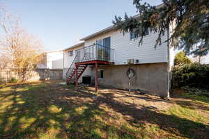 Back of house featuring stairway, a patio area and a wooden deck