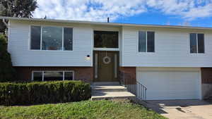 Split-entry featuring brick siding, a 2-car garage and concrete driveway