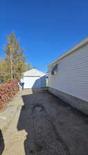 View of side of property with an outbuilding, a detached garage, and driveway