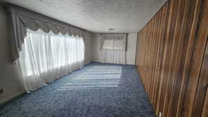 Family room featuring wooden paneling and a textured ceiling