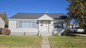 Bungalow-style house featuring a front lawn, & shingled roof.
