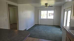 Unfurnished dining area with carpet and ceiling fan