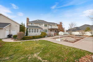 View of front facade featuring a chimney, stucco siding, and a patio