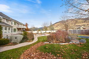 Fenced backyard featuring a mountain view and a balcony