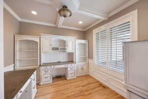 Unfurnished office featuring light wood-style flooring, beamed ceiling, crown molding, recessed lighting, and built in desk