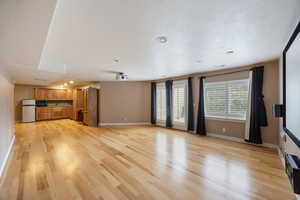 Unfurnished living room featuring light wood-style floors, recessed lighting, and a textured ceiling