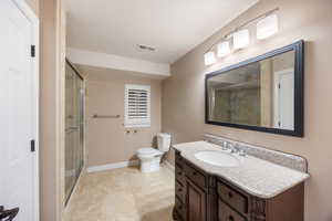 Bathroom with vanity, a shower stall, and light tile patterned floors