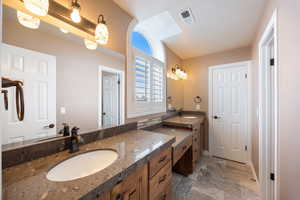 Full bath with two vanities and stone finish flooring