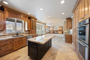 Kitchen featuring stainless steel appliances, backsplash, brown cabinets, open floor plan, and recessed lighting