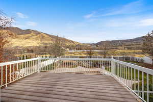 Deck with a mountain view and a yard