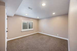 Carpeted empty room with recessed lighting