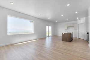 Unfurnished living room featuring light wood-style floors, recessed lighting, and a textured ceiling