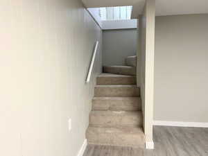 Stairway featuring wood finished floors and baseboards