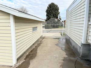 View of side of home featuring a gate and a patio area