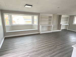 Unfurnished living room featuring wood finished floors