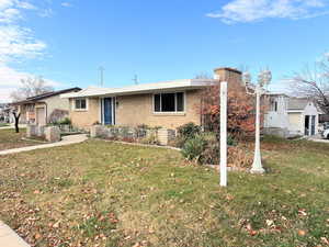 Single story home with a front lawn, brick siding, and a chimney
