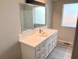 Bathroom with vanity, tasteful backsplash, and light wood finished floors