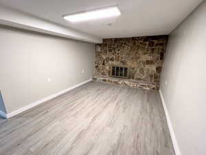 Unfurnished living room featuring light wood-style flooring and a fireplace