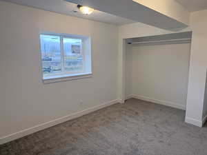 Unfurnished bedroom with light colored carpet, a closet, and a textured ceiling