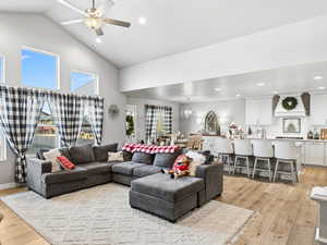 Living area featuring light wood-style flooring, recessed lighting, ceiling fan, and high vaulted ceiling