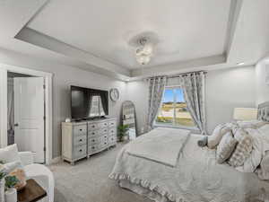 Master Bedroom featuring a raised ceiling, light colored carpet, a textured ceiling, recessed lighting, and a ceiling fan