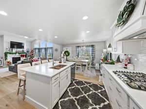 Kitchen with a breakfast bar area, tasteful backsplash, white cabinetry, appliances with stainless steel finishes, and recessed lighting