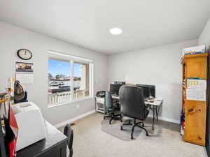 Bedroom or Office space with baseboards and light carpet