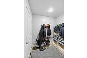 Mudroom featuring a textured ceiling and light wood-type flooring