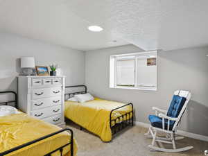 Bedroom featuring a textured ceiling and light carpet