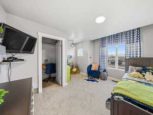 Bedroom featuring an office area and light carpet