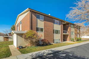 View of side of home with a yard and brick siding